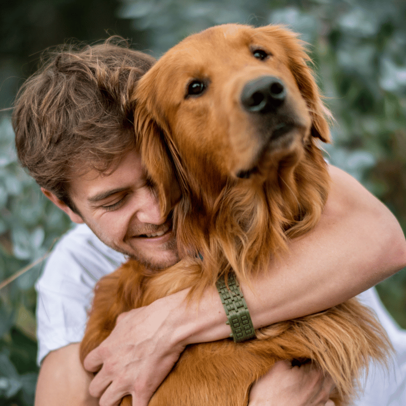 A man joyfully hugs a golden retriever outdoors, celebrating the loyalty that only a RunLoyal companion can bring home.