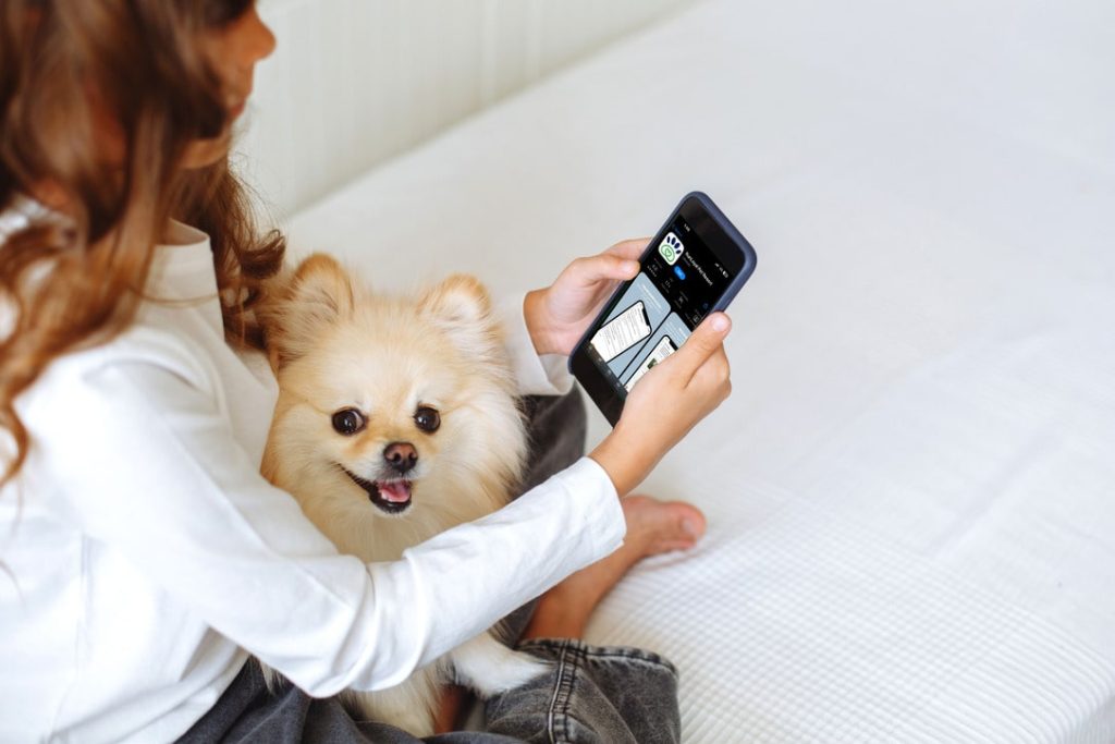 Woman using RunLoyal app with her Pomeranian on a cozy day at home