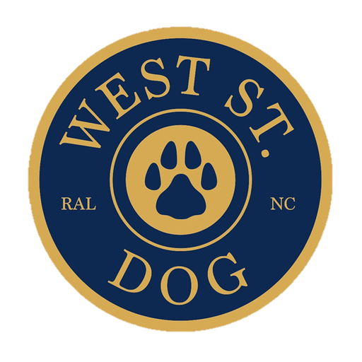A circular logo with a paw print in the center, surrounded by the text "West St. Dog RAL NC" on a blue and gold background, perfect for promoting dog training services.