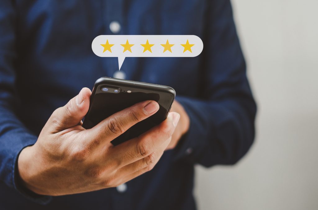 A person holding a smartphone with a five-star rating graphic above the device, showcasing top-notch pet care services.